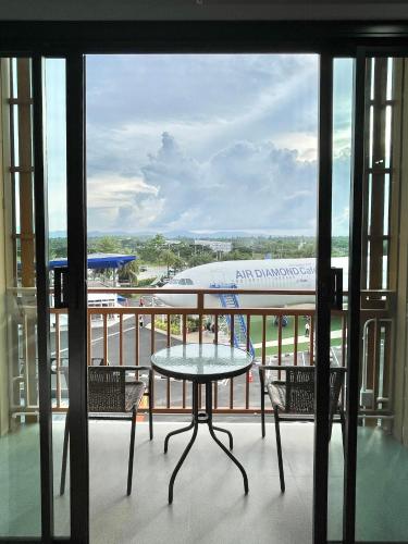a table and chairs on a balcony with an airplane at Air Diamond Hotel in Ban Nong Khong