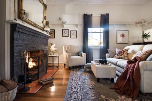 a living room with a couch and a fireplace at Birch House in Daylesford