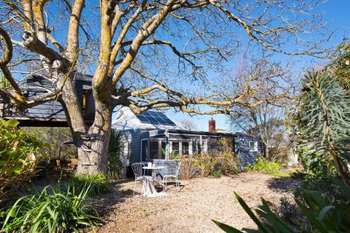 a house with a tree and a table and chairs at Birch House in Daylesford