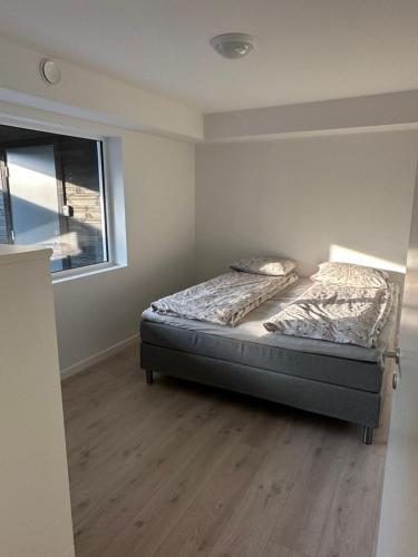 um quarto com uma cama e uma janela em Årossanden feriesenter, Søgne, Kristiansand em Kristiansand