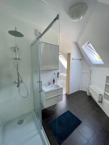a bathroom with a glass shower and a sink at AMBER Dębki in Dębki