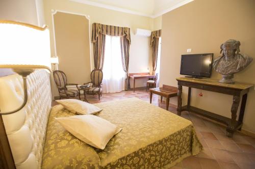 
a hotel room with a bed and a television at Palazzo Raho in Cefalù
