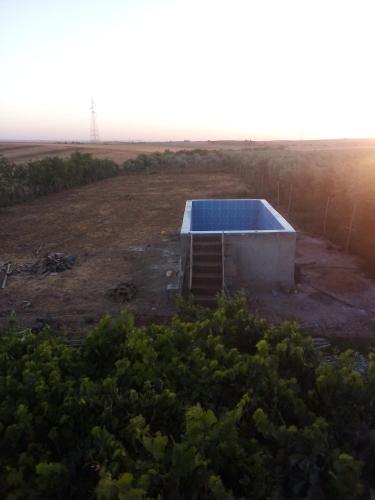 a building with a blue roof in a field at Nuit dans la ferme in Marrakech