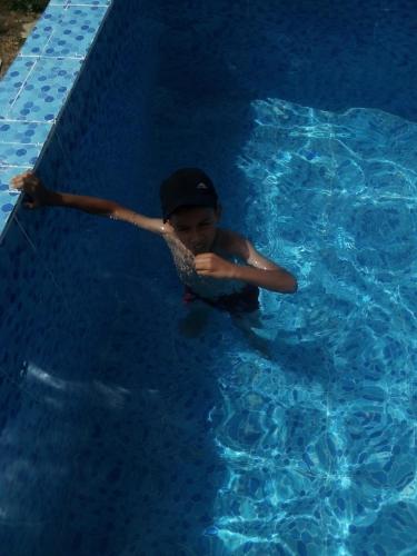 a young boy is in a swimming pool at Nuit dans la ferme in Marrakech