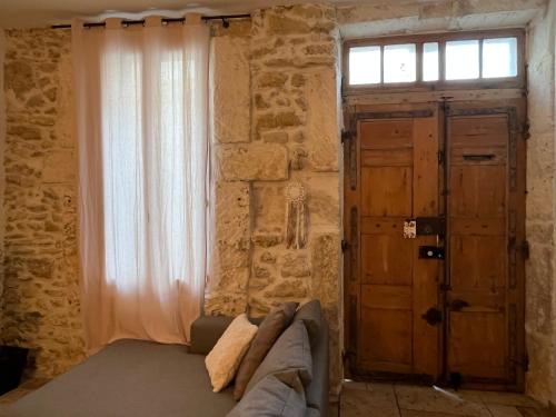 Habitación con sofá, ventana y puerta en Loccitan, en Capestang