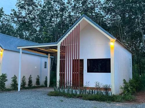 a small white house with a red and white at บ้านชมดาวรีสอร์ทบึงโขงหลง in Ban Don Klang