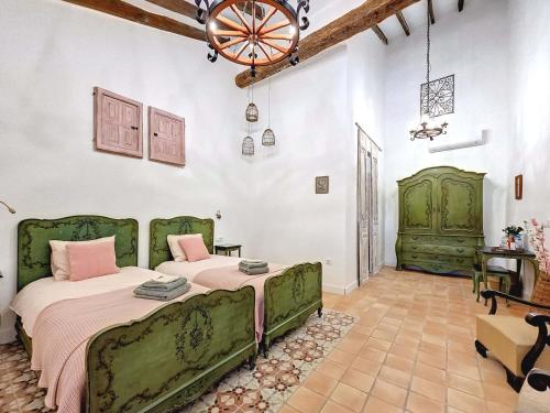 1 dormitorio con 2 camas y lámpara de araña en Casa Rodriguillo en Pinoso