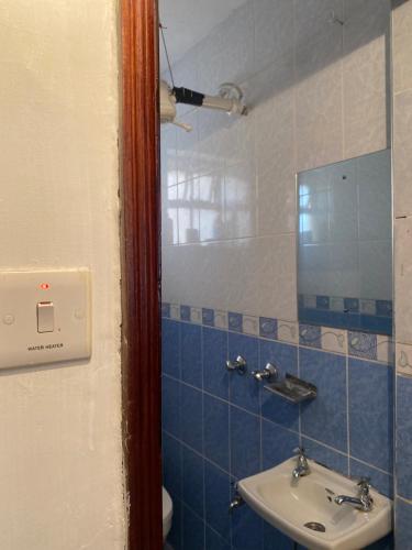a bathroom with a sink and a mirror at Private,secure 1bedroom in Nairobi west in Nairobi