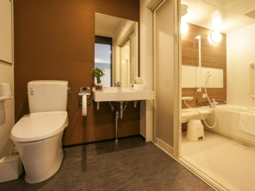 a bathroom with a toilet and a sink and a tub at HOTEL LiVEMAX Minamihashimoto Ekimae in Sagamihara