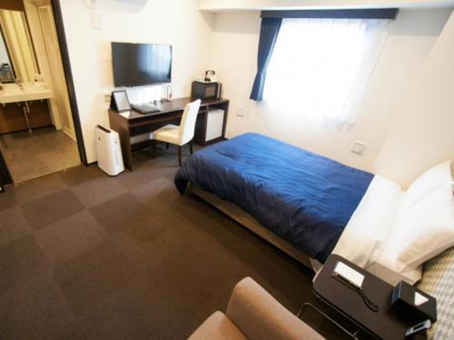 Habitación de hotel con cama y escritorio con ordenador en HOTEL LiVEMAX Minamihashimoto Ekimae en Sagamihara