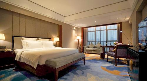 a bedroom with a large bed and a large window at Wyndham Grand Plaza Royale Ningbo in Ningbo