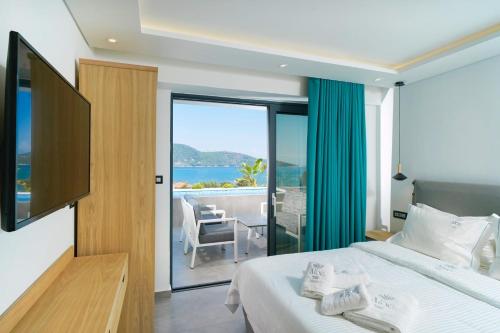 a bedroom with a bed and a view of the ocean at Aloe Elegant Suites in Skala Potamias