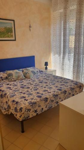 een bed met een blauw hoofdeinde in een slaapkamer bij palau casa vacanza le ginestre in Palau