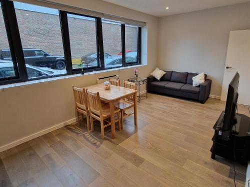 a living room with a table and a couch at Dream apartment Finchley 4 min walk to the train in Hendon