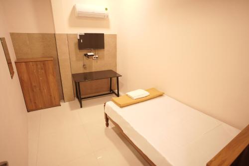 a small room with a bed and a table at Reach Residency in Cochin