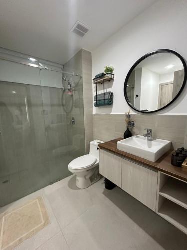 y baño con aseo, lavabo y espejo. en Apartamento Vacacional frente al mar en General Villamil Playas, en Playas