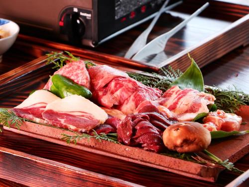 a tray of meat and vegetables on a table at 雲海の宿　月星亭 in Takeda
