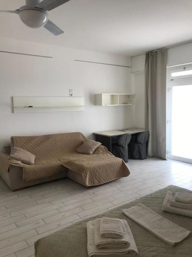 a living room with two beds and a table at fronteMare faleria1 in Porto SantʼElpidio