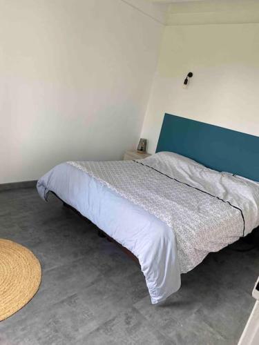 une chambre avec un lit avec une tête de lit bleue dans l'établissement Maisonnette à la campagne, à Douillet-le-Joly