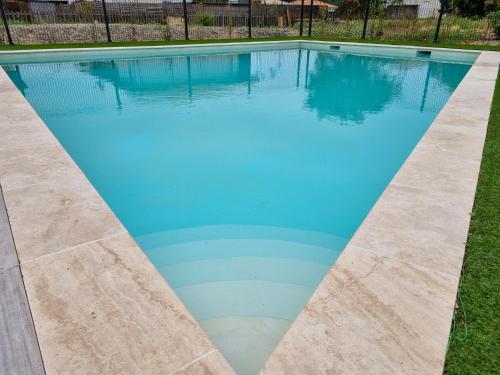 une piscine avec de l'eau bleue dans une cour dans l'établissement La Cabane de Mimizland ~ 10 min à pied de l'océan, à Mimizan