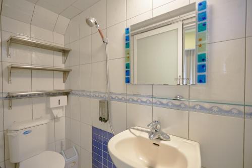 uma casa de banho com um lavatório, um WC e um espelho. em Santa's House em Xiaoliuqiu