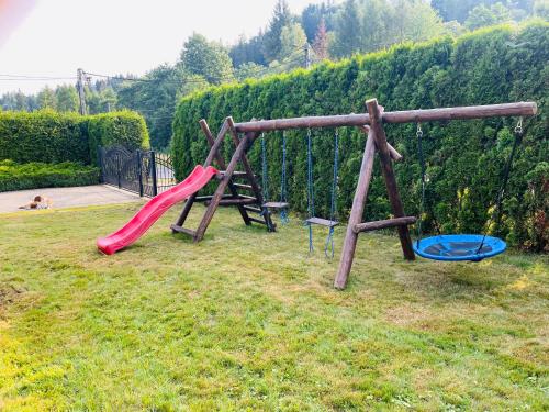 a playground with a red slide and a blue at Głębce 32A in Wisła