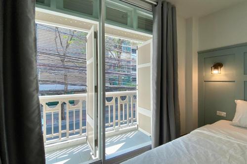 una camera da letto con finestra con vista su un balcone di Forgotten Hostel Silom a Bang Rak
