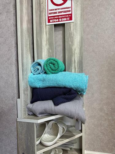 a pile of towels sitting on top of a shelf at Sport Hotel Terra in Ustʼ-Kamenogorsk