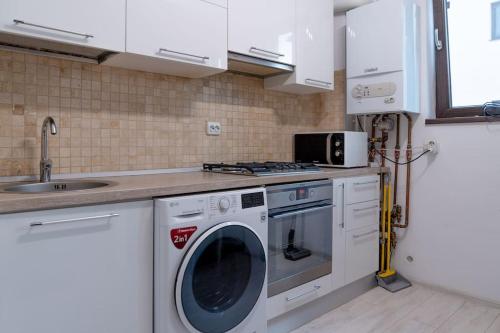 a kitchen with a washing machine and a sink at Apusului Residence Modern 2 Bedroom Apartment in Roşu