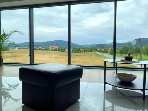 a living room with a table and a stool and a large window at Apartament 106 in Andrychów