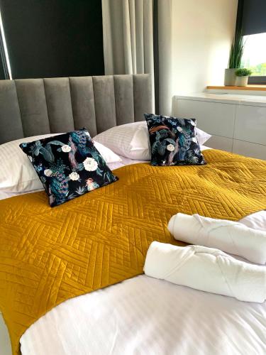 a bed with two pillows on top of it at Apartament 106 in Andrychów
