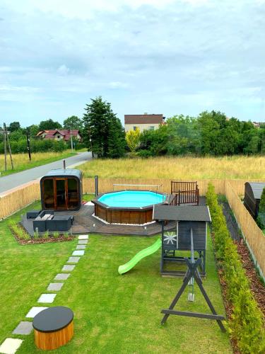 a backyard with a swimming pool and a playground at Apartament 106 in Andrychów