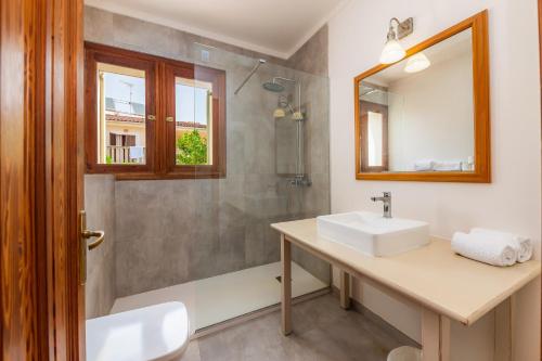 uma casa de banho com um lavatório e um chuveiro em Villa Sa Coma em Sa Coma