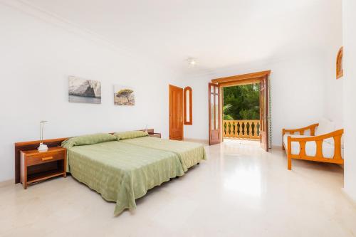 um quarto com uma cama, uma mesa e uma janela em Villa Sa Coma em Sa Coma