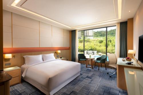 a hotel room with a bed and a desk and a table at Hilton Clark Sun Valley Resort in Clark
