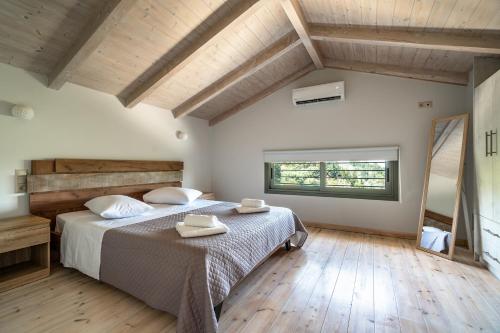 a bedroom with a large bed with two towels on it at Armonia Villa Lefkada in Kariotes