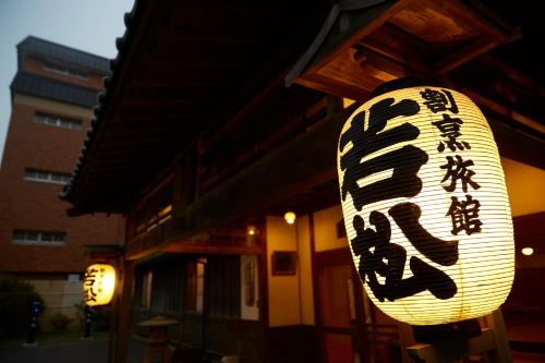 a sign for a restaurant in front of a building at Wakamatsu Hot Spring Resort in Hakodate