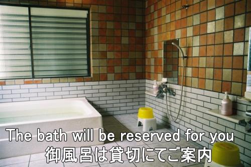 a bathroom with a bath tub and a mirror at Ryokan Ginsuikaku - Vacation STAY 40409 in Maizuru