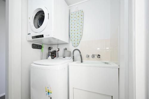 a bathroom with a washing machine and a sink at Spacious 3 Bedroom Delight - Shops & Beaches ZG1 in Caloundra
