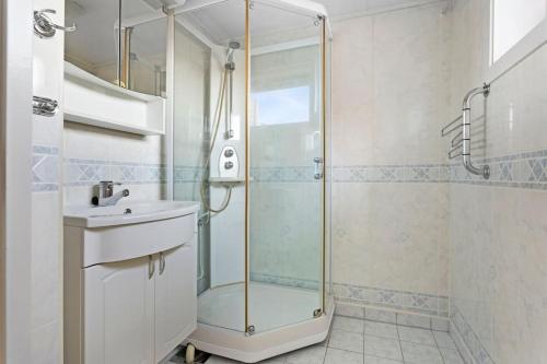 uma casa de banho com um chuveiro e um lavatório. em Oslo: Quiet and cosy home with garden and free parking em Grorud