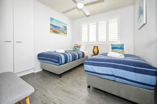 a bedroom with two beds and a chair in it at Spacious 3 Bedroom Delight - Shops & Beaches ZG1 in Caloundra