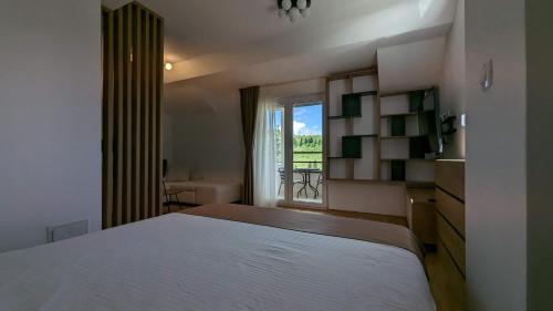 a bedroom with a large white bed and a window at Apartman ANA in Žabljak