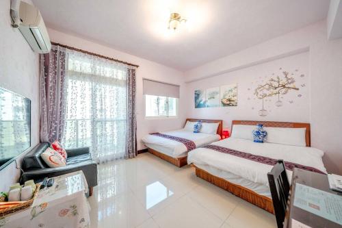 1 Schlafzimmer mit 2 Betten, einem TV und einem Fenster in der Unterkunft Shanghai Time in Hualien