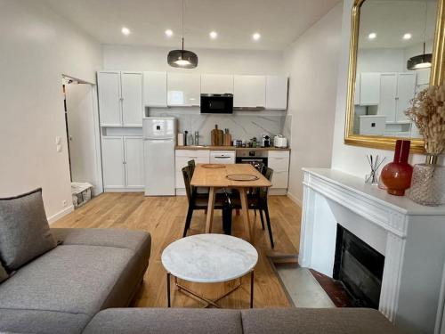 un salon avec un canapé et une table et une cuisine dans l'établissement Cozy studio in center Paris (quartier Marais), à Paris