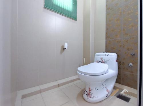a bathroom with a white toilet in a room at Mciti Suites by Evernent in Miri