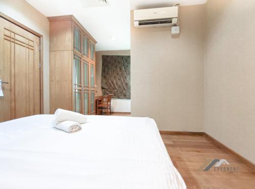 a bedroom with a white bed and a air conditioner at Mciti Suites by Evernent in Miri