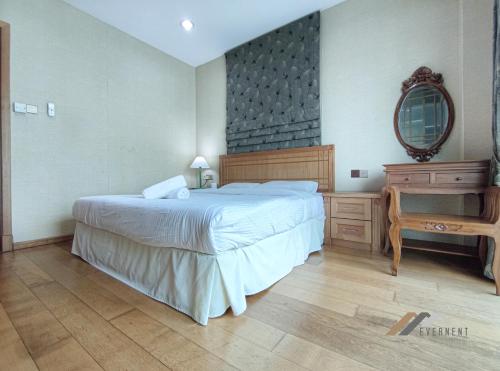 a bedroom with a bed and a dresser and a mirror at Mciti Suites by Evernent in Miri