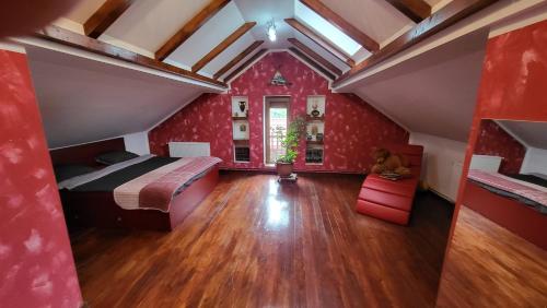 um quarto com paredes vermelhas, uma cama e um piso de madeira em Casa in Oradea ! em Oradea