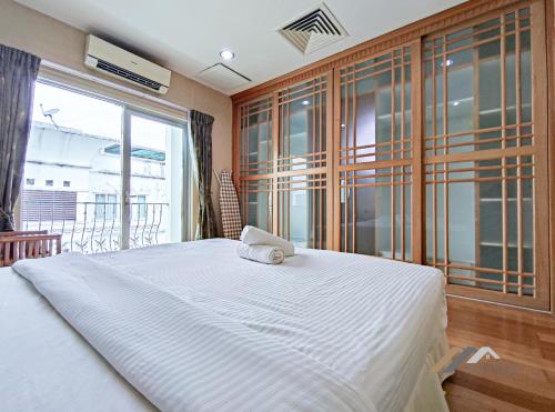 a bedroom with a large bed and a large window at Mciti Suites by Evernent in Miri