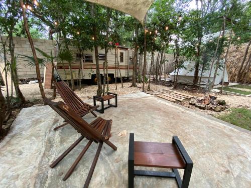 2 Stühle und eine Schaukel auf einer Terrasse mit einem Haus in der Unterkunft MAKEX-CAMPER in Tulum